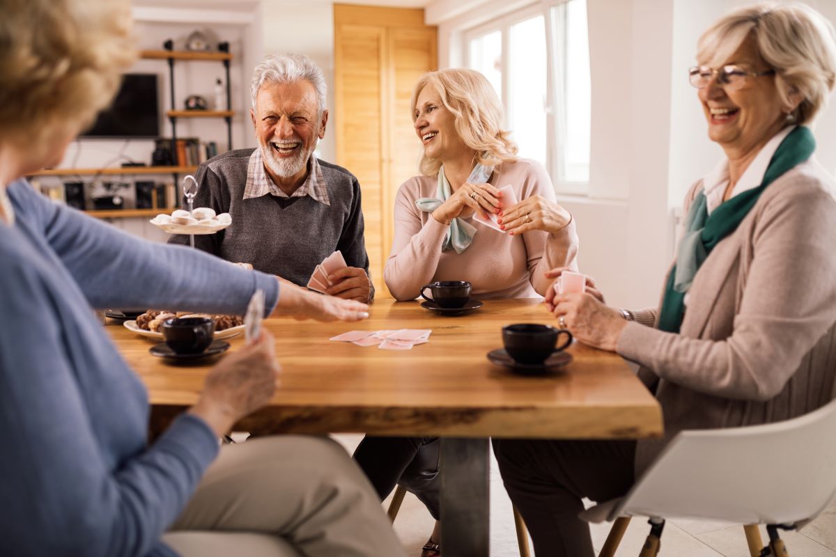 Cheerful senior friends playing cards 